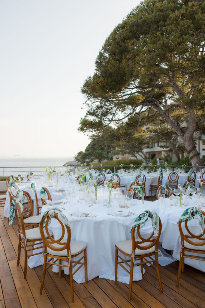 A-serpentine-table-beautifully-set-with-elegant-dinnerware-and-refined-wedding-decor-hotel-les-roches-blanches-cassis-wedding-in-provence-sea-bride-and-sun