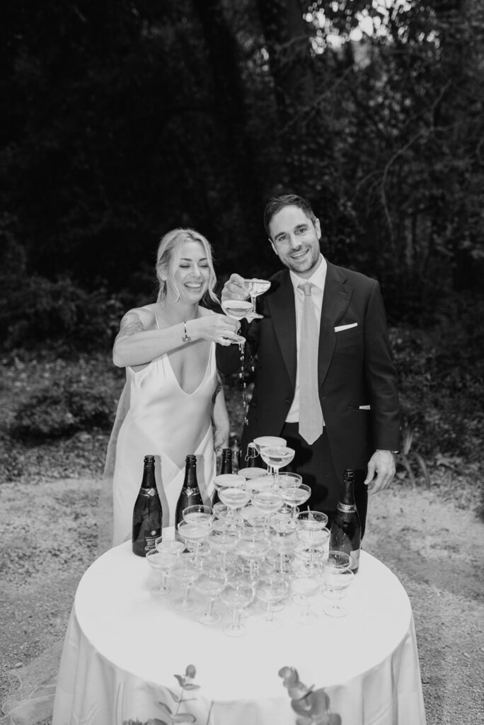 Bride-and-groom-standing-next-to-champagne-tower-celebrating-wedding-reception-wedding-in-provence-domaine-de-lamanon-sea-bride-and-sun