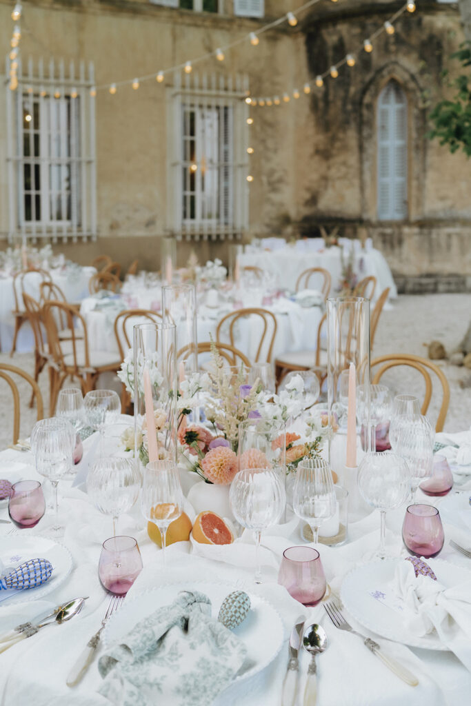 Wedding-tables-elegantly-set-with-floral-arrangements-and-soft-color-palette-chateau-de-robernier-wedding-in-provence-sea-bride-and-sun